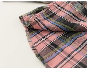Close-up of pink plaid cotton fabric showing detailed stitching and woven texture