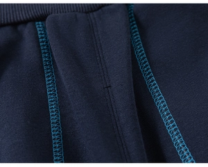 Detailed close-up of navy blue knit pants featuring professional zigzag stitching on the waistband