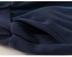 Macro detail of navy blue knit fabric with contrast stitching on boys casual trousers