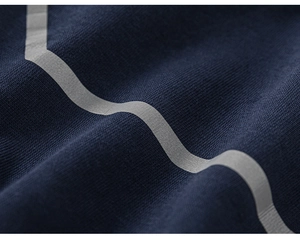Detailed macro view of dark blue knit fabric with reflective silver wavy stripe accents