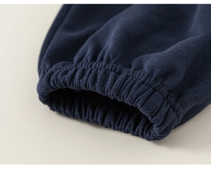 Detailed macro view of the elastic ribbed cuffs and stitching on navy blue joggers