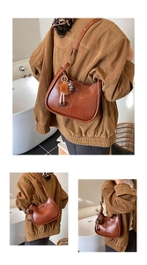 Dettaglio della borsa hobo marrone vintage con pompon in peluche e ciondolo leopardato