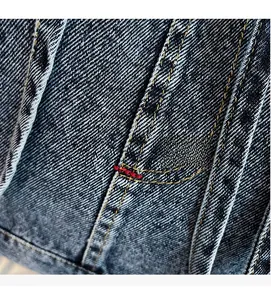 Detailed macro view of vintage denim fabric with orange double stitching and red bartack detail
