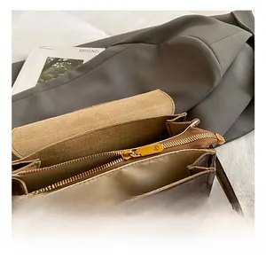 Dettaglio dell'interno della borsa in pelle marrone con cerniera dorata e fodera beige