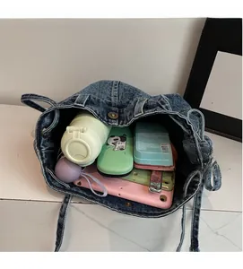 Interior view of denim bucket bag showing large capacity for water bottle and tech items