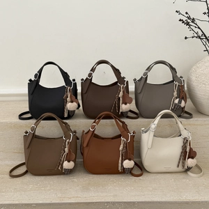 Collection of saddle bucket bags in diverse colors with plush charms and tassels