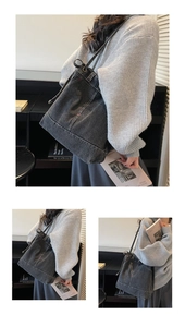 Detail view of denim tote bag featuring side drawstrings and stylish red stitching accents