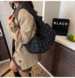 Vue latérale d'un mannequin portant un grand sac cabas matelassé noir en nylon léger