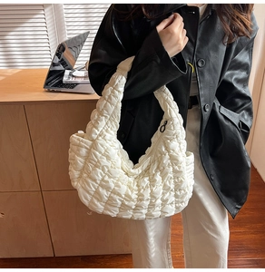 Détail du sac cabas matelassé blanc avec texture plissée et accent de fermeture noire