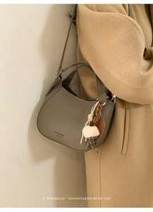 Detail of taupe crescent bucket bag with lychee texture and ice cream charm