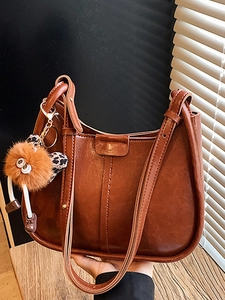 Borsa a spalla marrone retrò in ecopelle con trama litchi e ciondolo di peluche