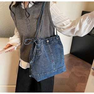 Detail of vintage denim tote bag featuring real jeans pocket design and metal button closure
