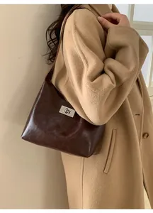 Detail of dark brown vintage leather shoulder bag with silver metal swivel lock closure