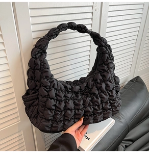 Détail du sac à bandoulière noir plissé avec texture nuage et large poignée intégrée