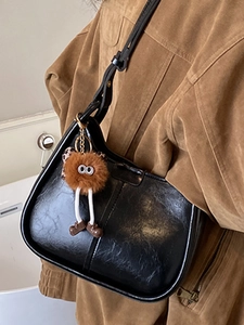 Borsa a tracolla nera lucida da donna con un simpatico ciondolo a sfera di peluche