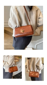 Dettaglio di borsa a tracolla vintage in pelle marrone con chiusura a scatto in metallo dorato