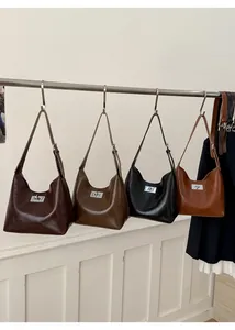 Detail of hobo shoulder bags in brown, black, and tan with vintage metallic locks