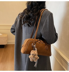 Brown suede shoulder bag with contrast stitching and cute plush dog charm detail