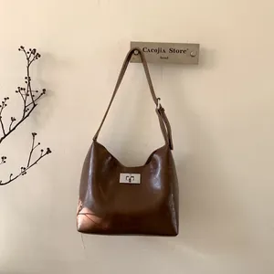 Detailed view of retro brown oil wax leather shoulder bag with silver metal swivel lock