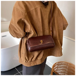 Dettaglio borsa a tracolla vintage in pelle marrone scuro con chiusura a scatto dorata