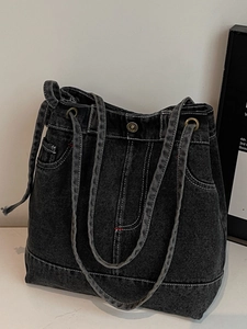 Vintage black denim tote bag with metal button closure and decorative pocket stitching