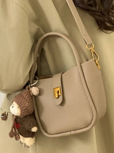 Sac seau beige en cuir grainé avec fermoir doré et charmant petit ours suspendu
