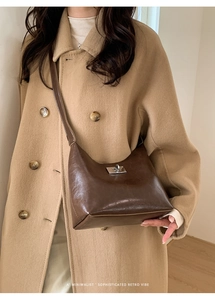 Detail of dark brown retro shoulder bag with silver clasp and glossy finish leather