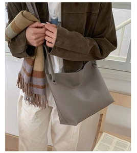 Minimalist large dark grey tote bag in lychee texture worn with casual winter outfit
