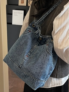 Vintage denim shoulder tote bag with washed denim texture and industrial style pockets