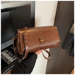 Dettaglio della borsa in ecopelle marrone scuro con chiusura a rotazione in metallo oro