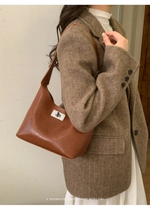 Detail of vintage brown leather underarm bag with silver turn-lock and hobo structure