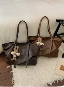 Close-up of vintage tote bags with soft textured leather and cute plush rabbit charms