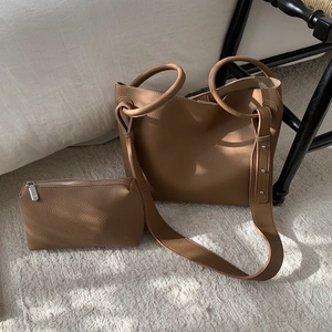 Caramel pebble leather tote and small pouch set with silver stud details on strap
