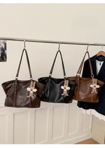 Detailed view of three vintage leather tote bags in brown, black, and caramel with bunny charms
