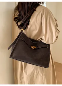 Detail of vintage brown leather tote bag showing the elegant golden metal twist lock closure