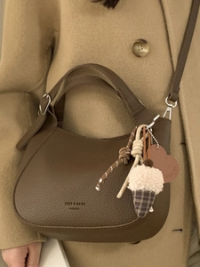 Brown lychee leather crescent bucket bag with woven charms and detachable shoulder strap