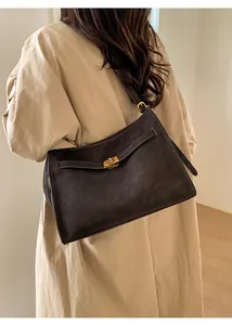 Close-up of a retro dark brown leather tote bag featuring a premium gold metal buckle