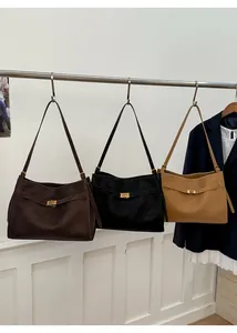 Close-up of frosted leather shoulder bags in coffee, black and khaki with gold square locks