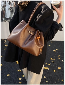 Détail d'un cabas en cuir marron rétro avec pampille et boucle métallique décorative
