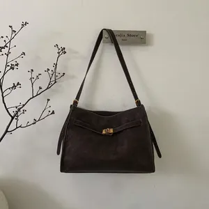 Detail view of deep brown vintage tote bag with adjustable strap and golden buckle