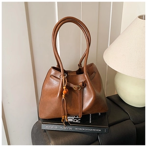 Détail d'un sac cabas vintage en cuir marron avec un gland élégant en perles de bois