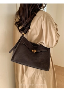 Macro view of retro dark coffee tote bag texture with elegant gold metal buckle detail