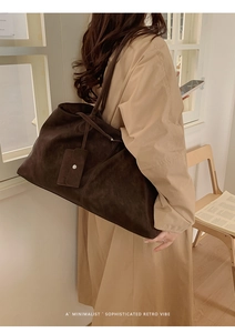 Detail view of large dark brown tote bag with suede texture and matching mini pouch bag