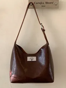 Vintage brown glossy leather shoulder bag with a silver metallic twist lock closure