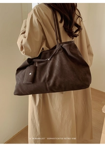 Detail of a large dark coffee faux leather tote bag showing its vintage texture and charm