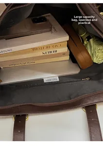 Internal view of a spacious dark brown tote bag showing main compartment and zipper pocket