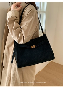 Detail of minimalist black tote bag with vintage gold twist-lock and matte leather finish