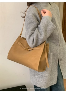 Detail of camel leather tote with retro metal buckle and adjustable shoulder strap