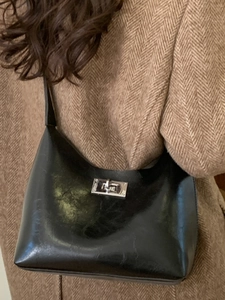 Modern black glossy leather hobo bag with silver rotating clasp for winter fashion