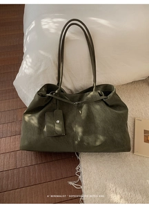Détail du sac cabas minimaliste en cuir vert olive avec une petite pochette suspendue